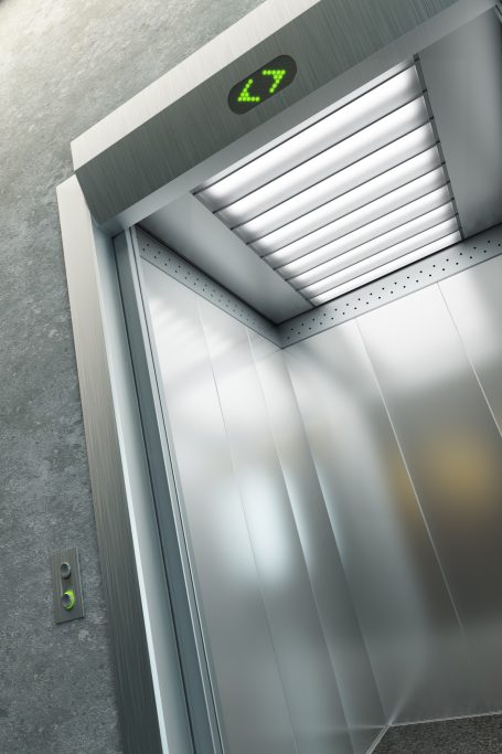 Leerer Aufzug mit modernem, metallischem Innenraum und beleuchtetem Dach.