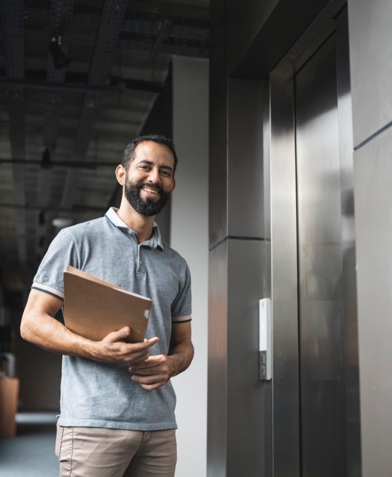 Zwei Geschäftspartner besiegeln ihre Zusammenarbeit mit einem Handschlag, während im Hintergrund ein Laptop steht.