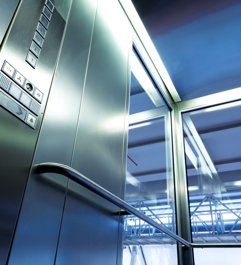 Dieses Bild zeigte die Kabine eines modernen Aufzugs mit Glaselementen und Aufzug-Drucktasten